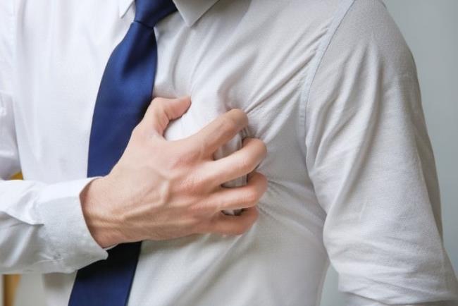 גבר מחזיק את ידו באזור הלב, אדנוזין להחזרת קצב הלב לפעילות נורמלית